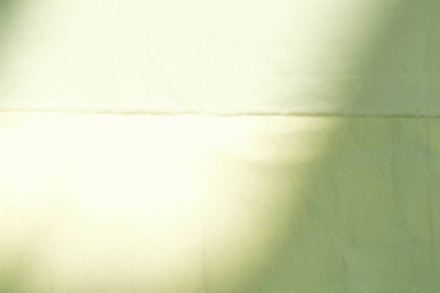 Soft folds of cream and sage linen in warm light
