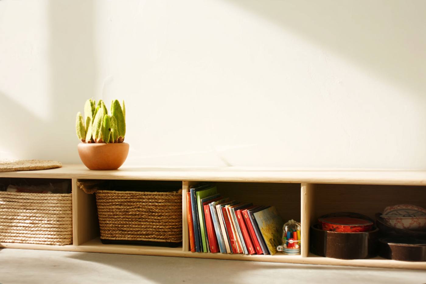 A warm early-learning shelf of picture books and baskets