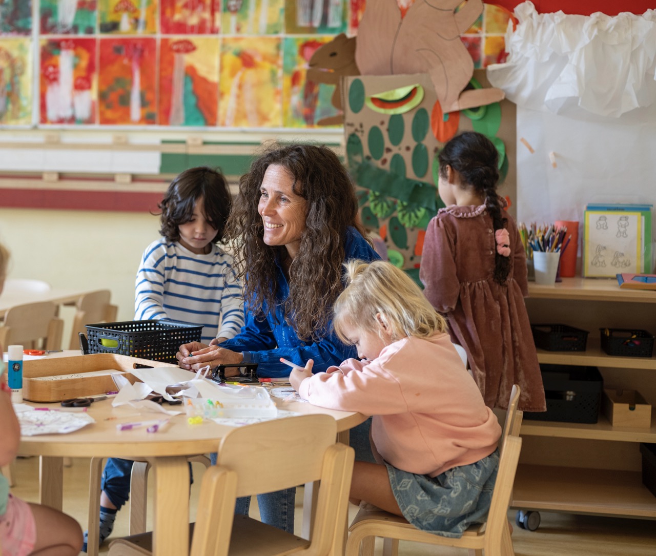 An educator and children in a calm early learning room, the kind of real moment a childcare video captures