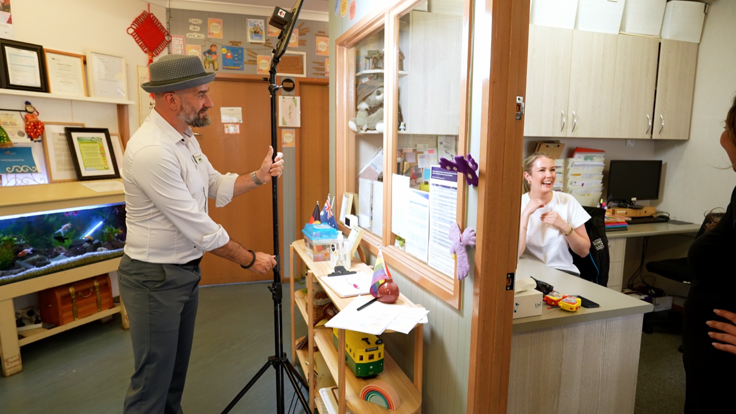 Arek Rainczuk setting up a light for a video shoot inside an early learning centre