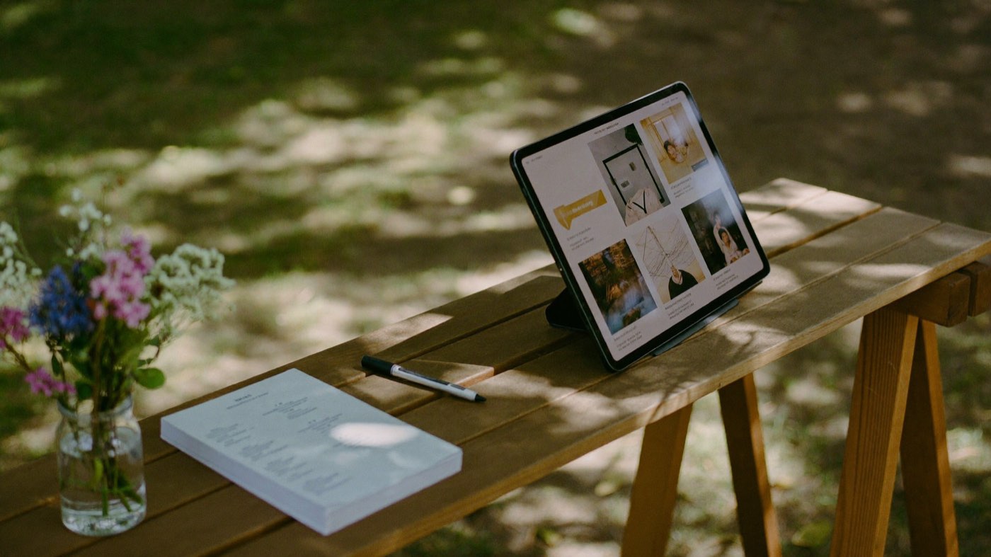 A welcome table at an open day, with a tablet ready for signing families in
